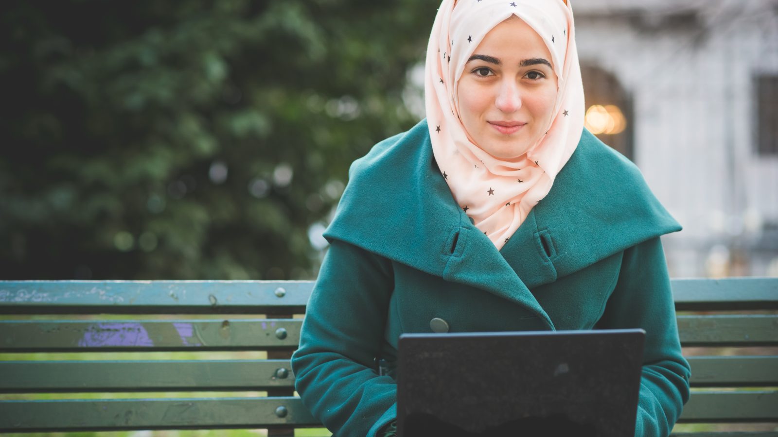 Tjej med hijab sitter med en dator