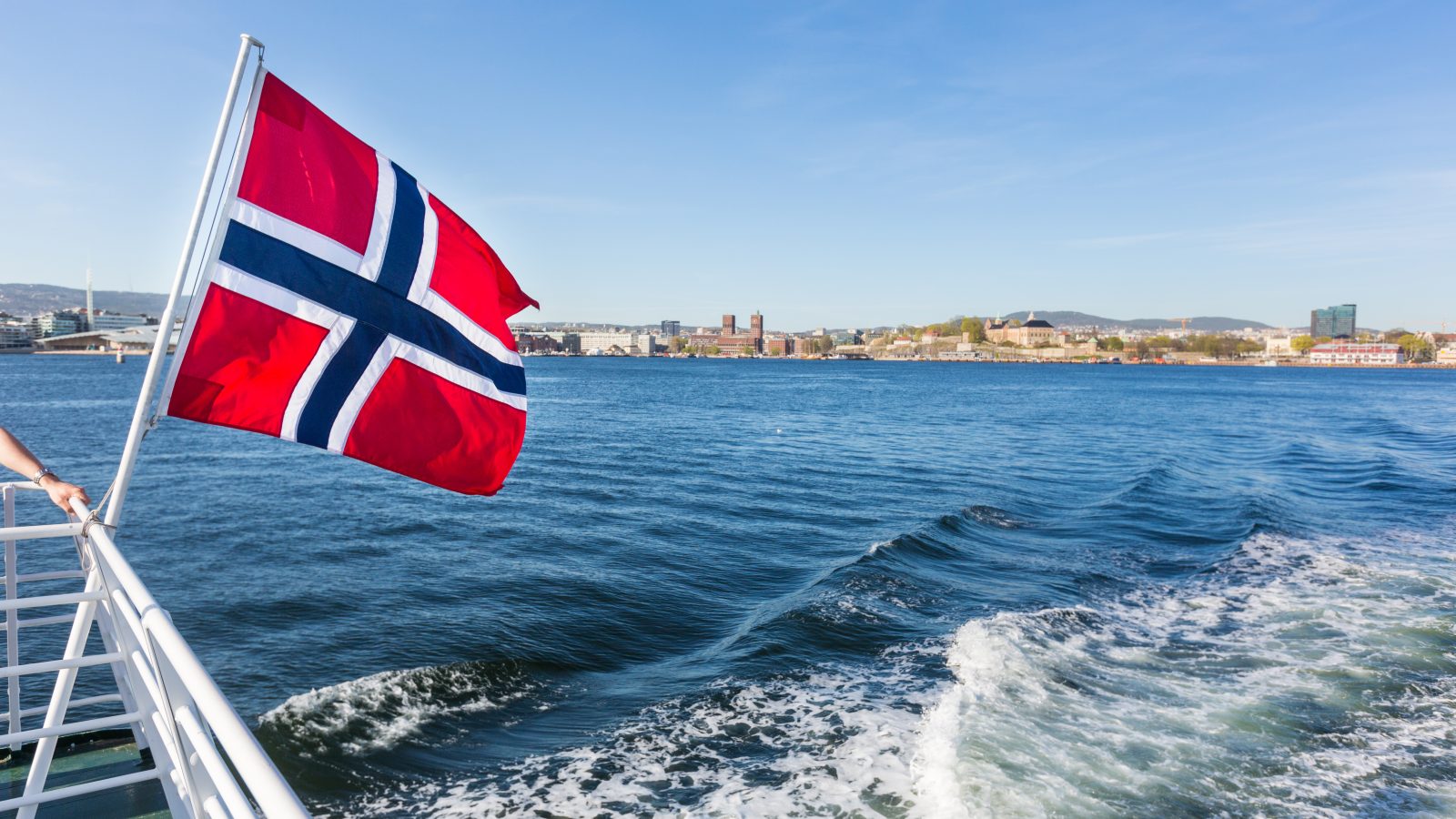 Norska flaggan på en båt med vatten som bakgrund