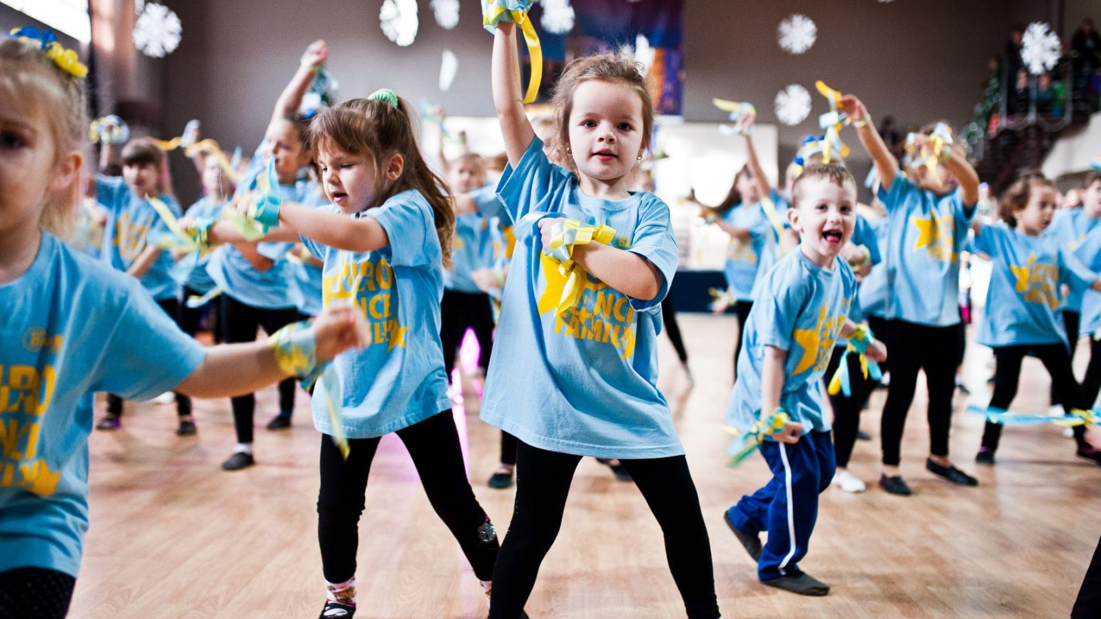 En grupp barn i en gymnastiksal som leker med ukrainska vimplar