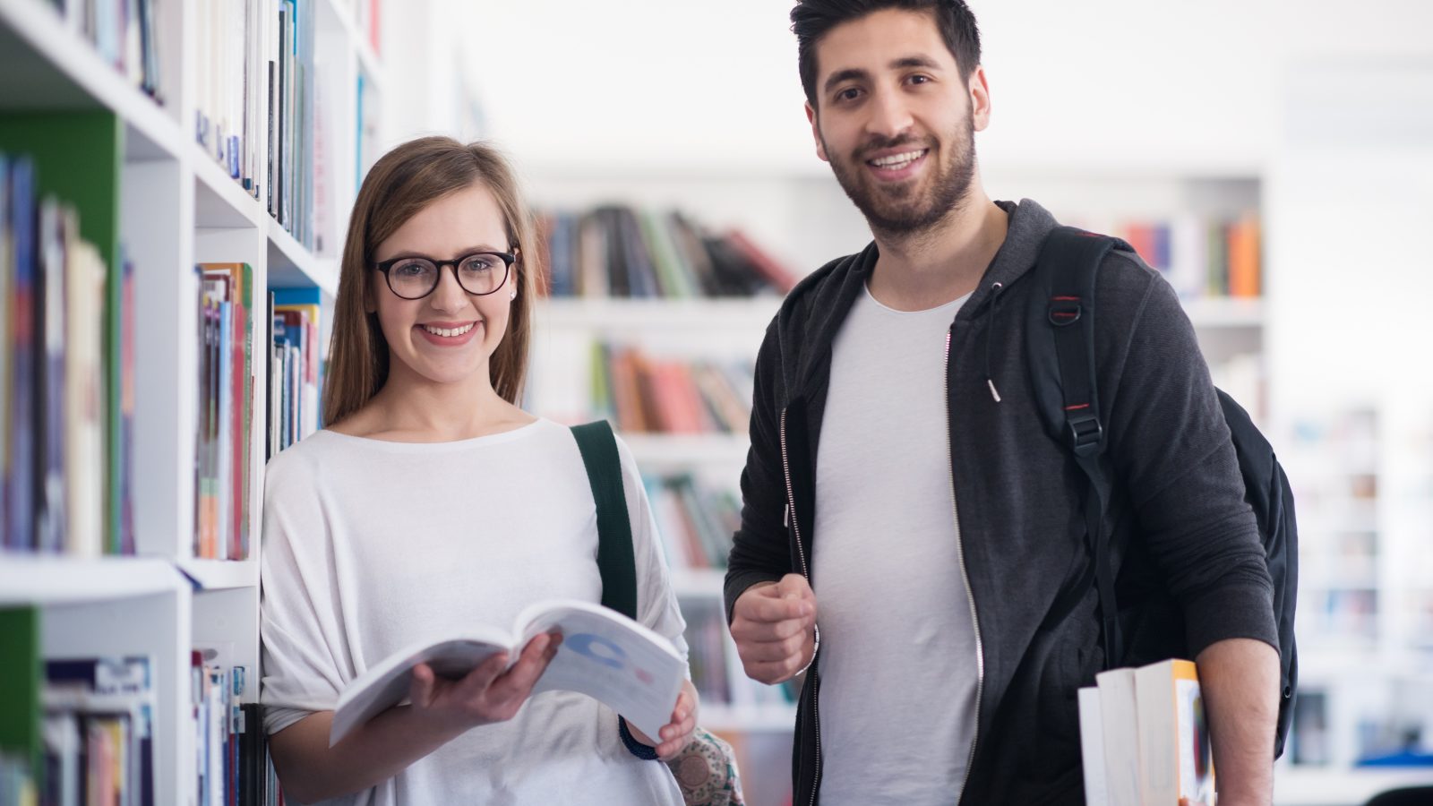students couple in school library have discussion about book
