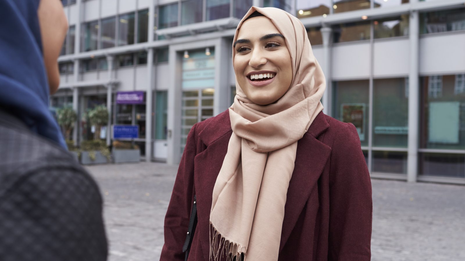 Kvinnor med hijab pratar utanför sin arbetsplats.