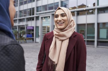 Kvinnor med hijab pratar utanför sin arbetsplats.