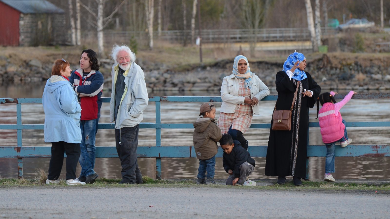 Åtta personer med olika ursprung och i olika åldrar vid en flod