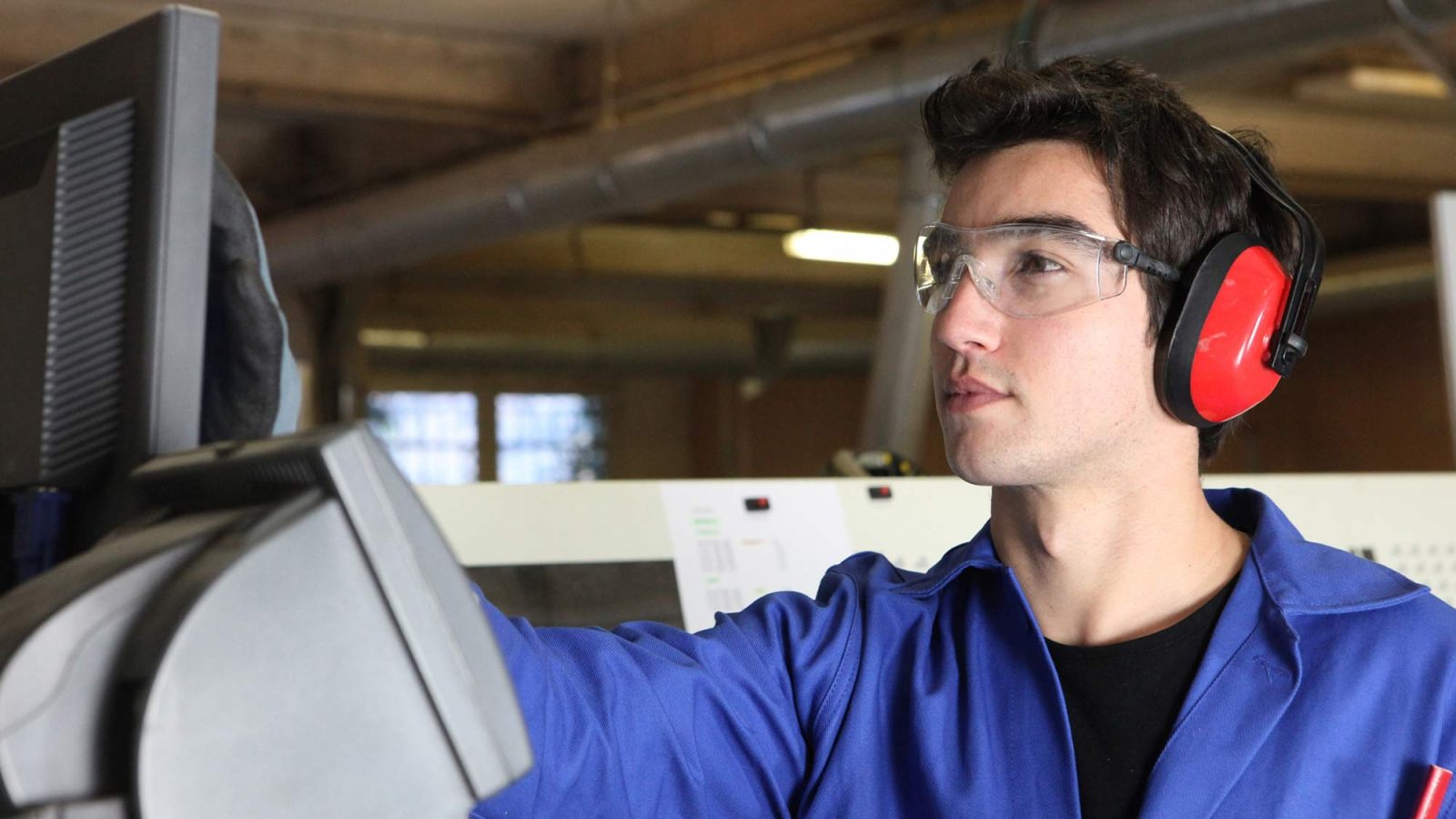 young man operating machine in factory