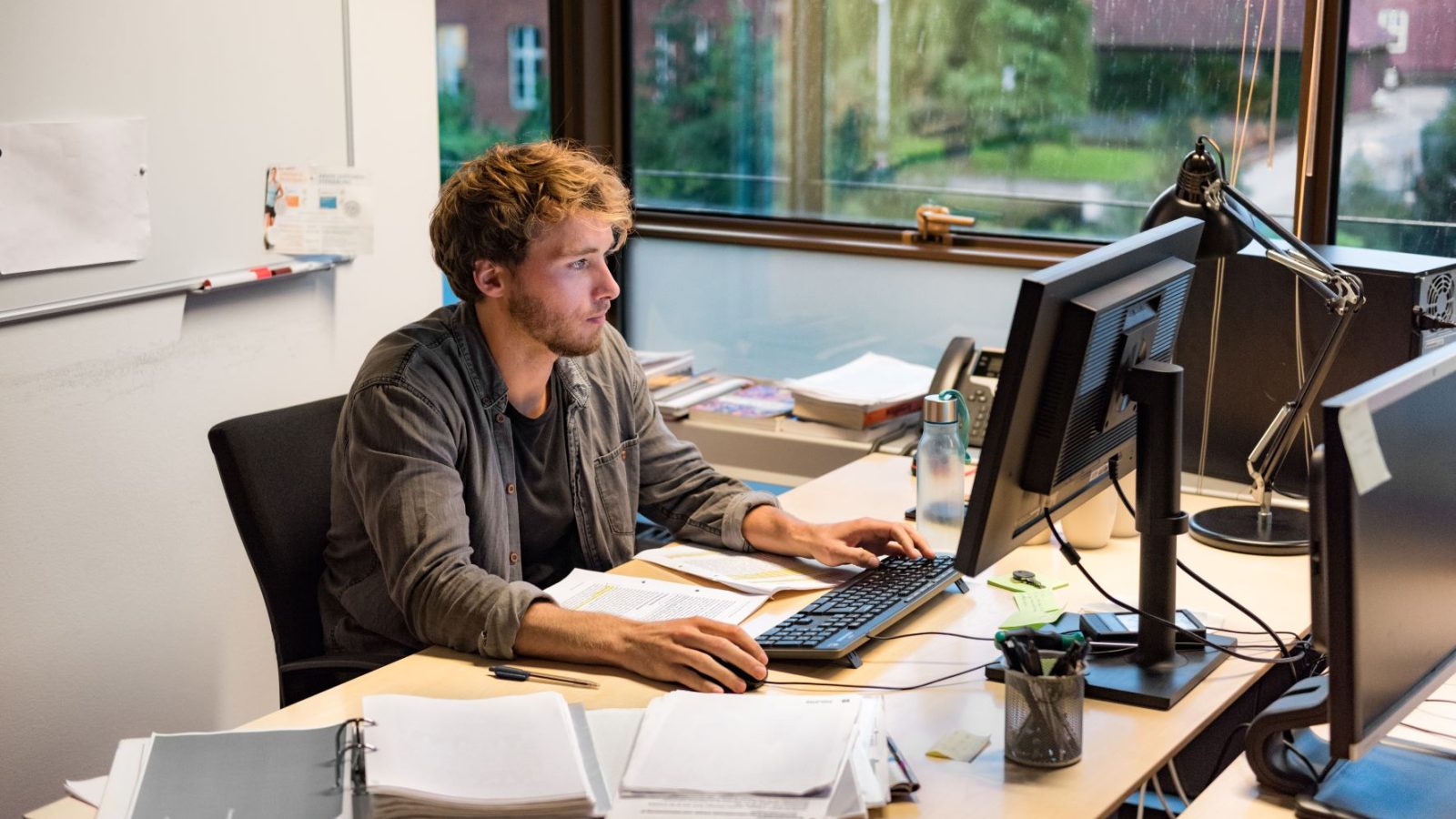 Young phd student typing at computer