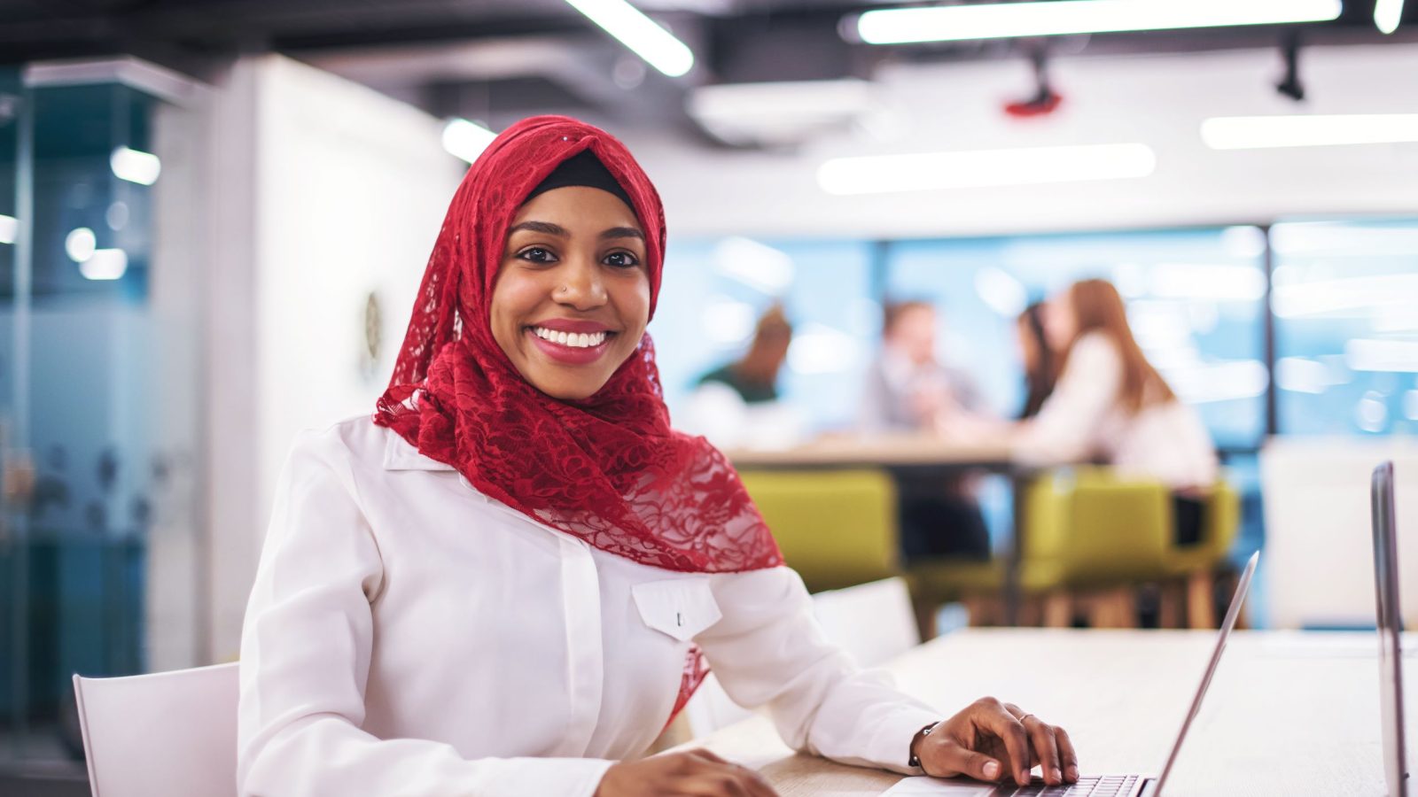 Ung kvinna i hijab som ler mot kameran