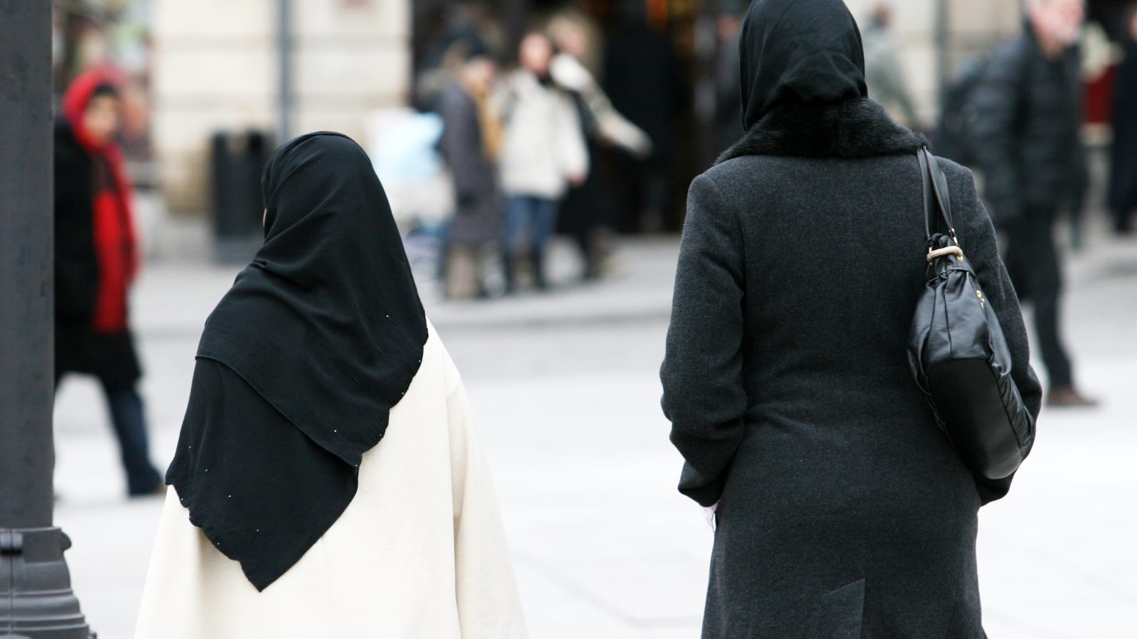 Två kvinnor med hijab promenerar.