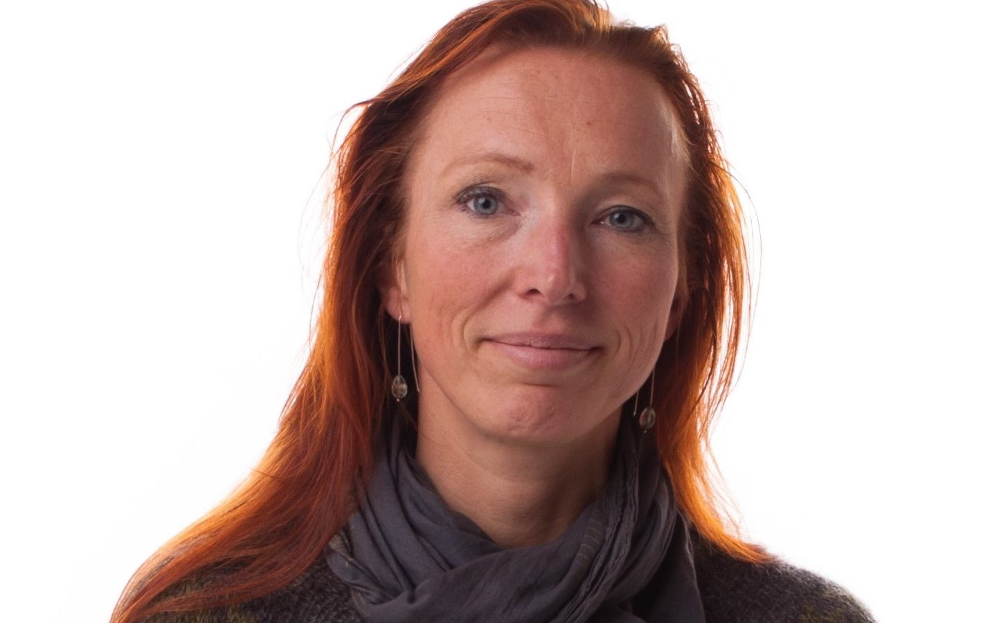 Foto av Christina Elle. Hon har rött långt hår och grön tröja