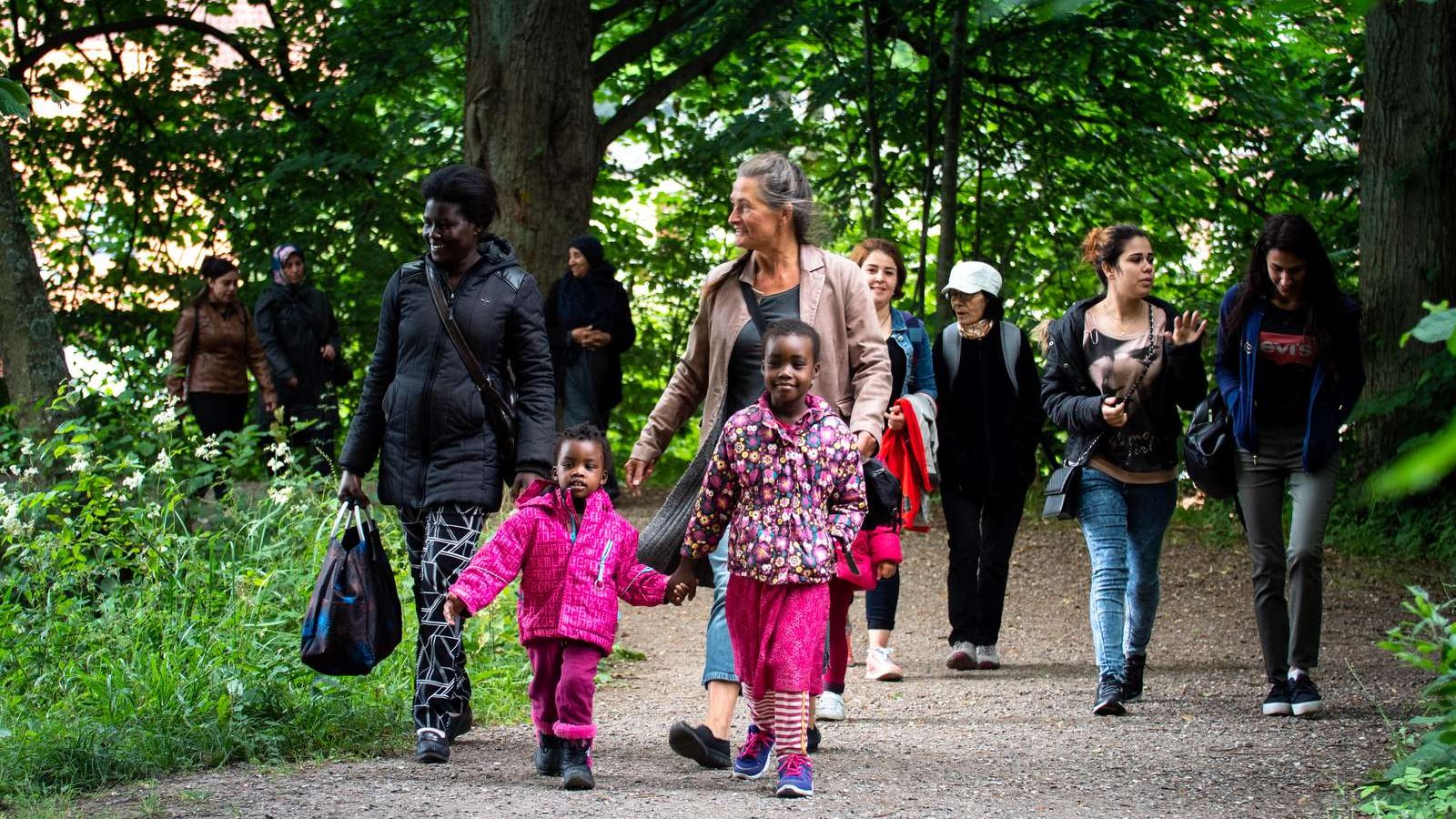 Barn och vuxna på promenerar i en park