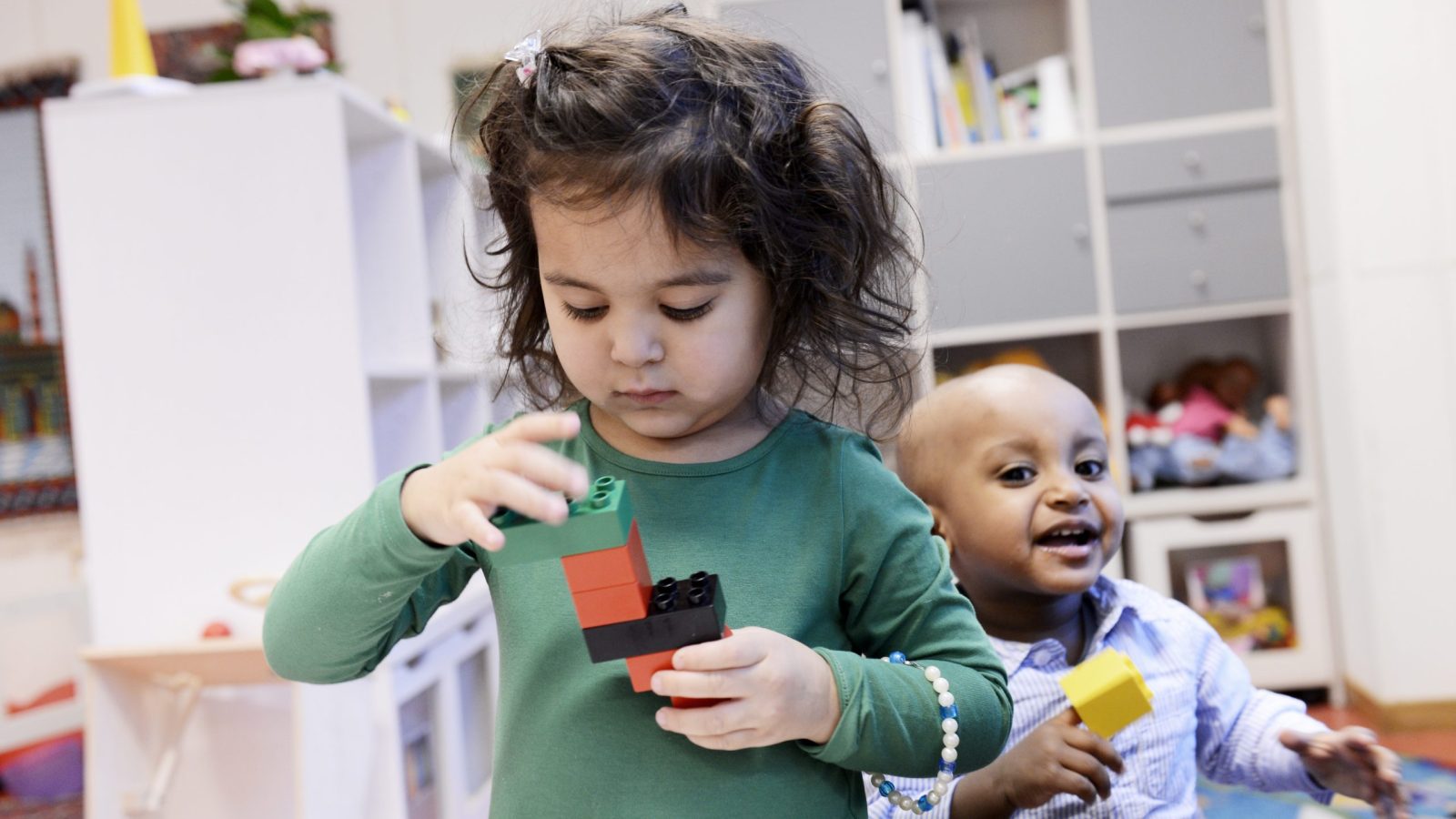 Två förskolebarn leker med lego