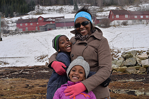 Mamma med sina två barn i vintrigt landskap