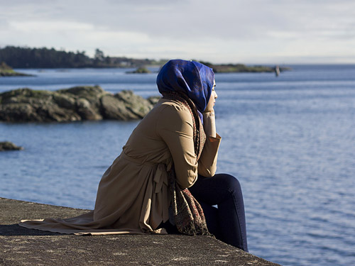 Kvinna med sjal ser ut över havet