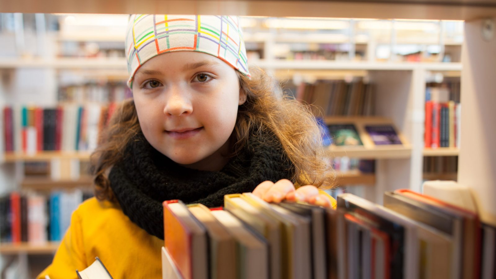 Flicka på bibliotek