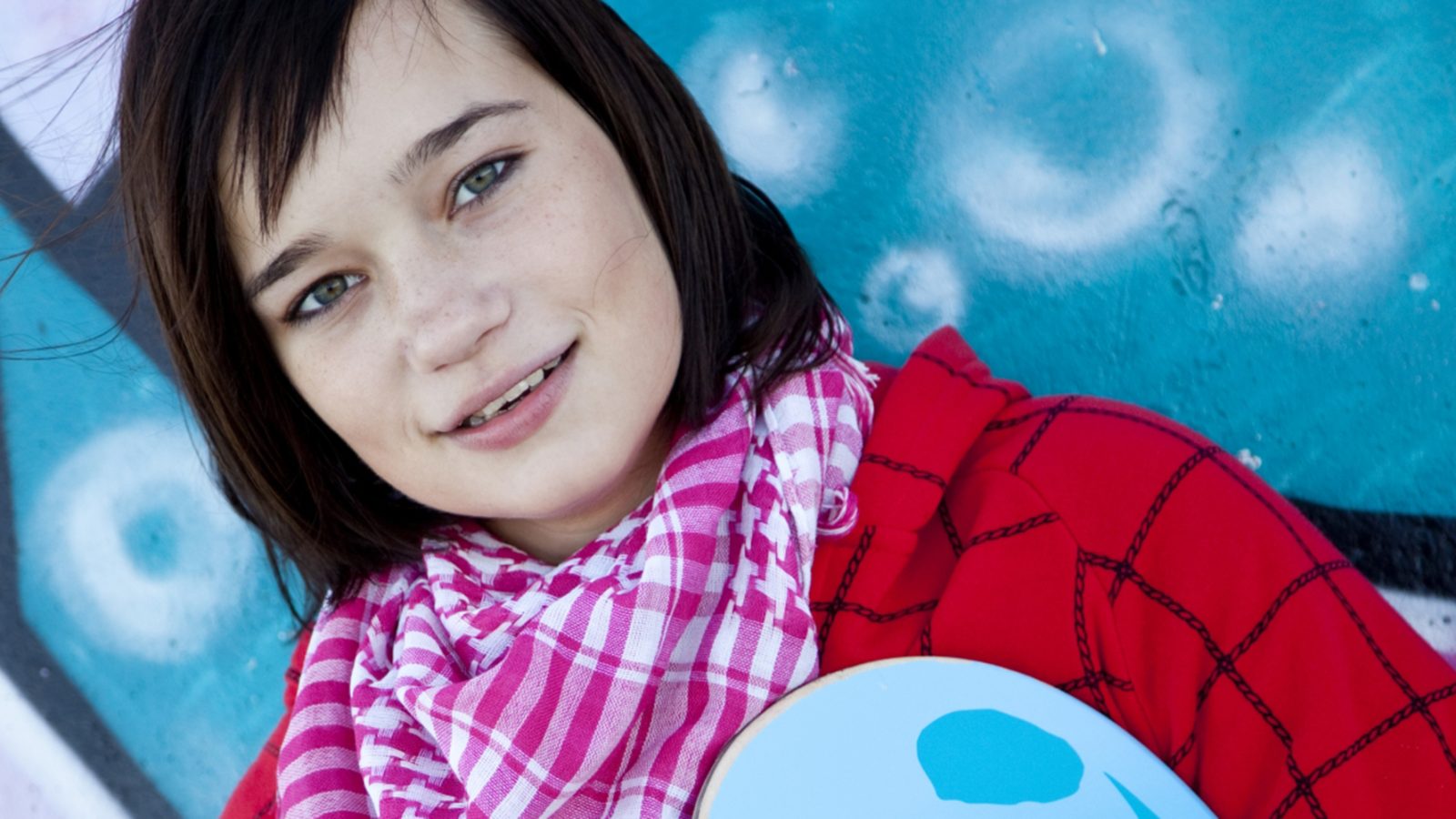 Flicka tittar ralt in i kameran, blå bakgrund