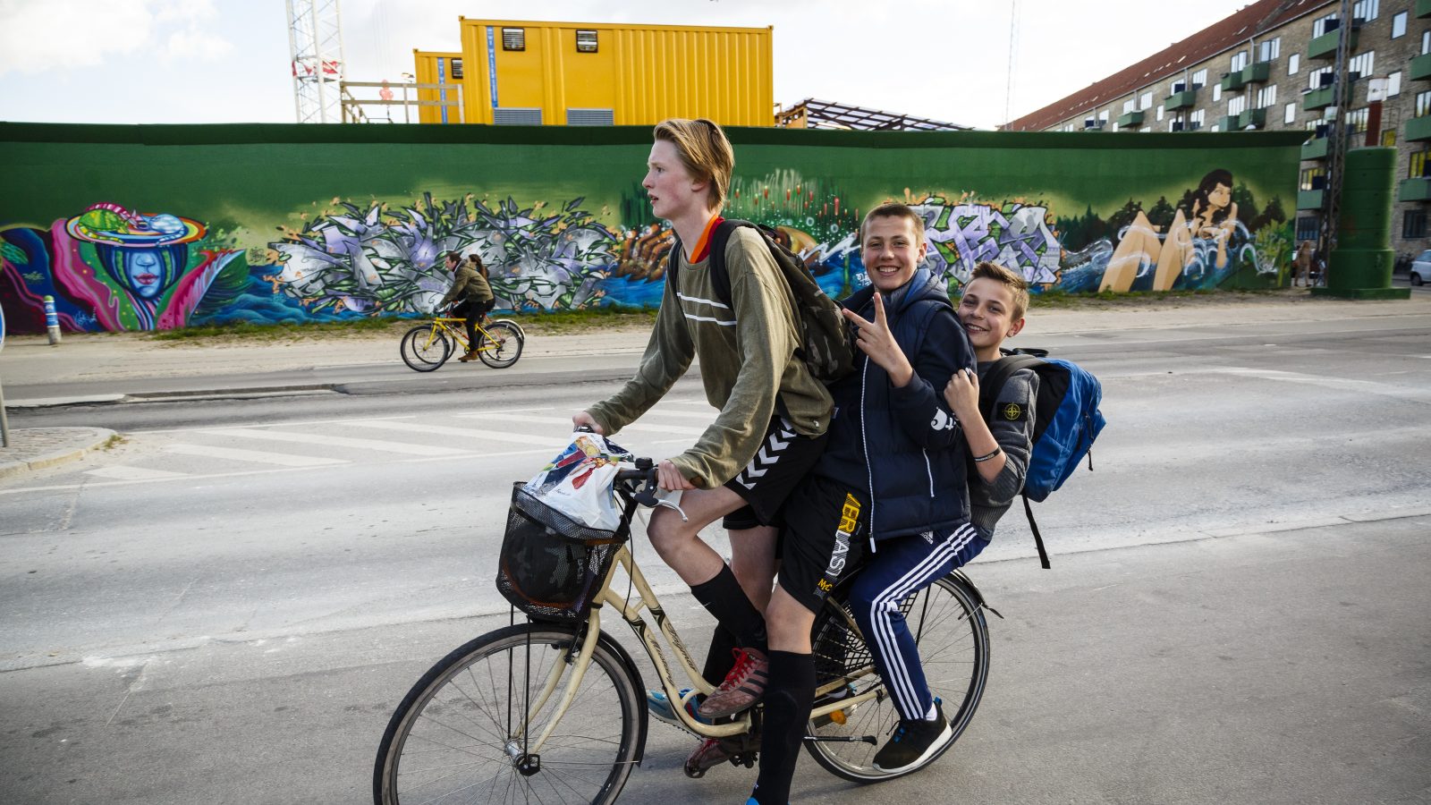 Tre unga killar på cykel
